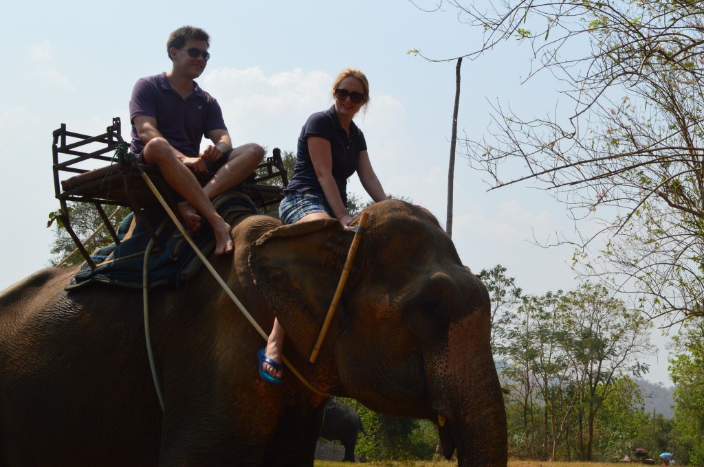 Shannon and Stephen riding elephants in Kanchanaburi, Thailand