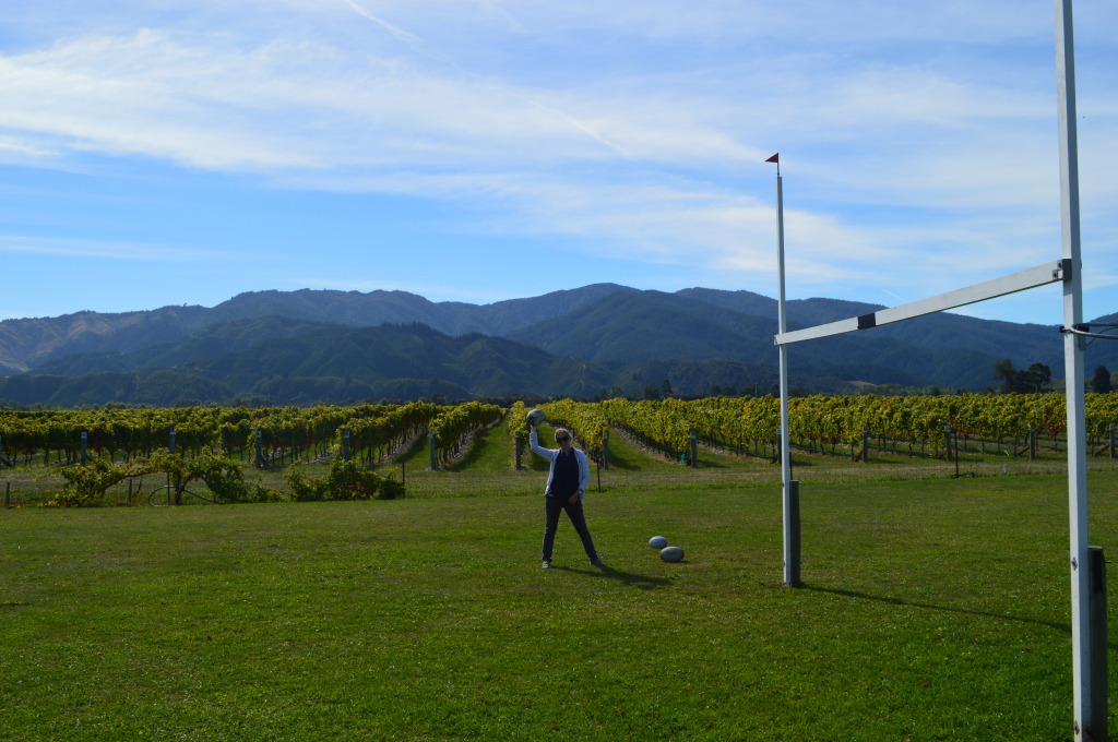 Shannon on a rugby pitch next to a vineyard in Marlborough, New Zealand